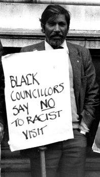 Man with plackard saying Black Councillors say no to racist visit